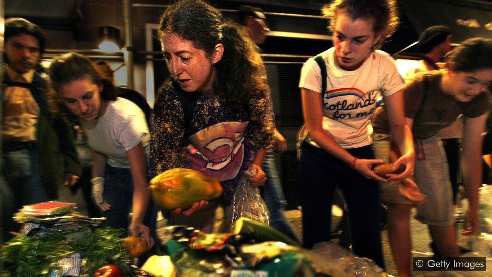 A growing number of people go dumpster diving, taking discarded food from bins outside restaurants and supermarkets (Credit: Getty Images)